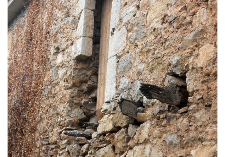 Θύρα εισόδου στον όροφο της ανατολικής όψης με τμήματα των προεξέχοντων ξύλινων δοκων που υποβάσταζαν τον ξύλινο εξώστη