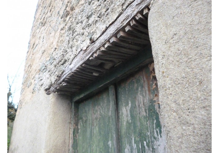 Πόρτα με ξύλινο οριζόντιο πρέκι, κάτω από το οποίο έχουν τοποθετηθεί λεπτά ξύλα για την πρόσφυση του σοβά