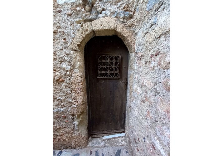 Πόρτα με μεταλλικές λεπτομέρειες μπροστά από το άνοιγμα και στο πόμολο