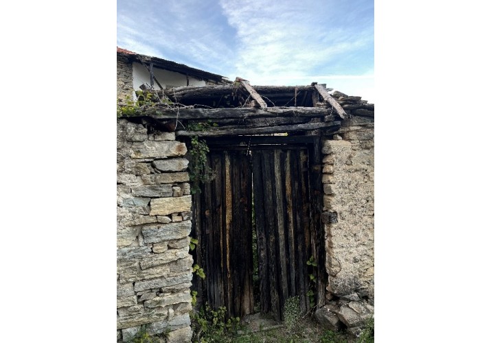 Δίφυλλη αυλόπορτα από ελαφριές σανίδες που σκεπάζεται από δίρριχτη στέγη