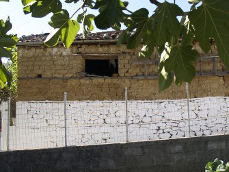Παράδειγμα επιχρίσματος ασβέστη σε λίθινη τοιχοποιία στην βάση κτηρίου με ωμόπλινθους.