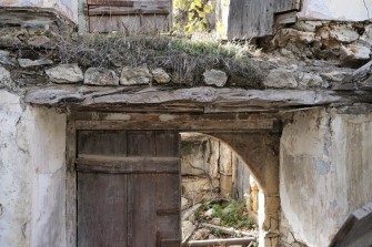 Ξύλινη εξώπορτα με κομμάτι κορμού στο πρέκι