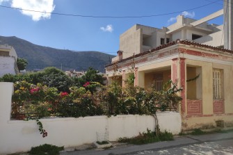 Ψηλή οικοδομή δίπλα σε νεοκλασική κατοικία