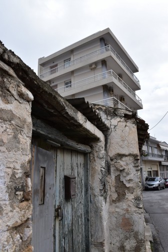 Ψηλή πολυκατοικία δίπλα σε παραδοσιακή κατοικία